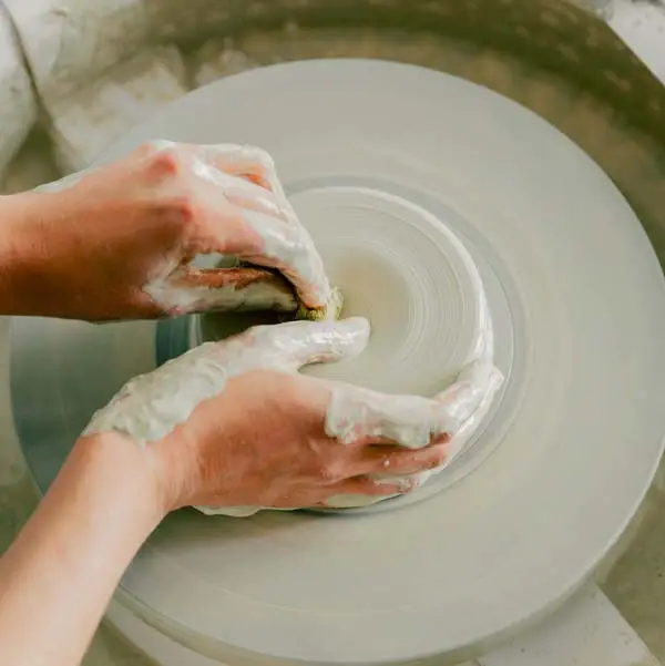 Woman making a ceramic bowl on a spinning wheel